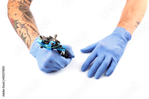 Tattooist hands in blue glo...
