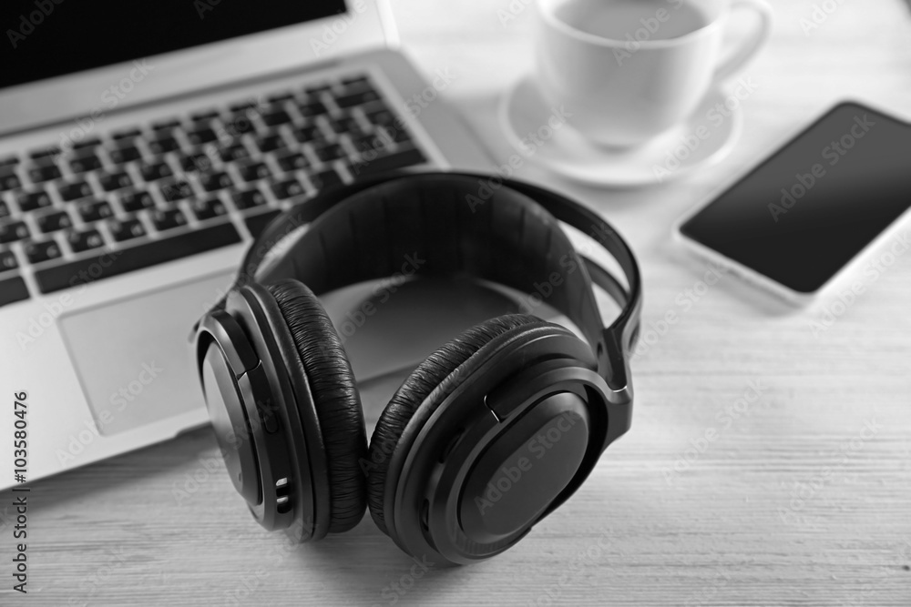 Headphones and laptop on wooden table closeup Headphones and laptop on wooden table closeup