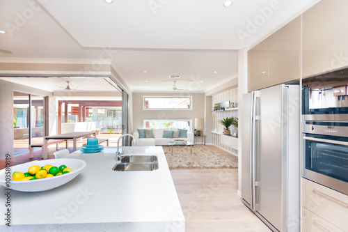 View of a living room and an exterior patio from the modern kitc photo