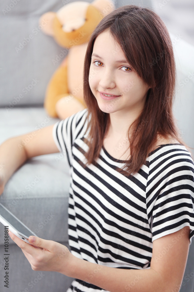 Beautiful girl with digital tablet on carpet indoor