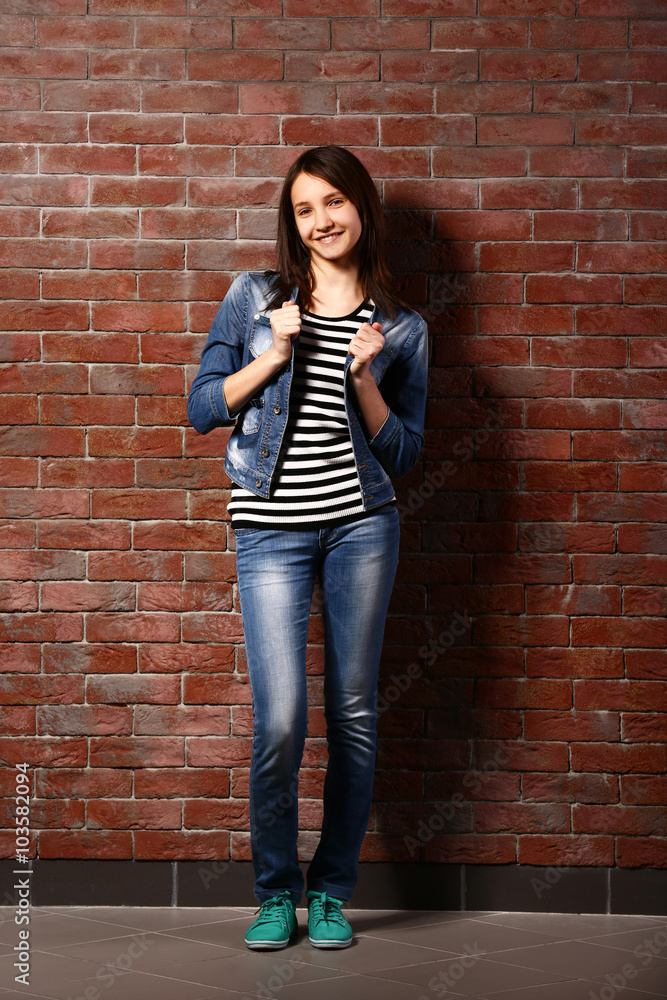 Beautiful young girl posing on brick background Beautiful young girl posing on brick background