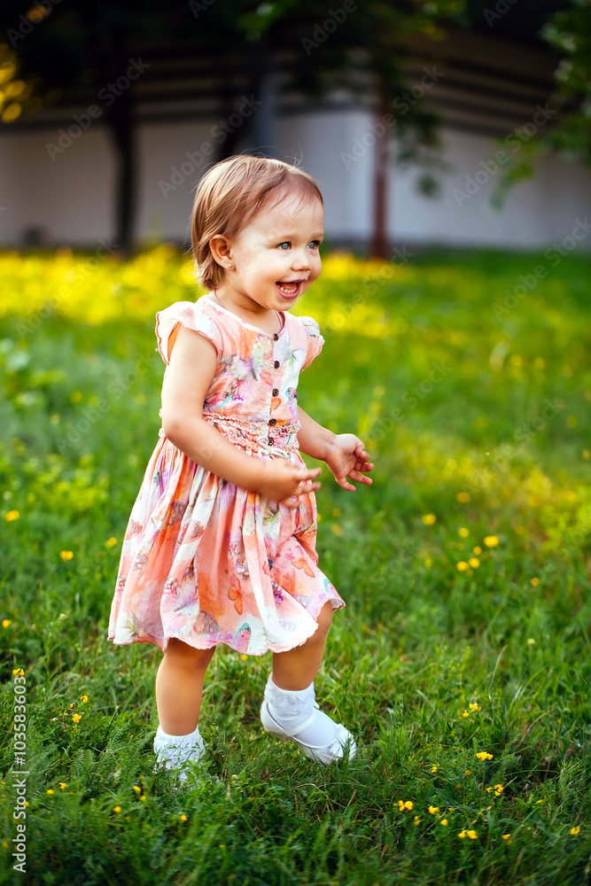 Happy cute little girl running on the grass in the park. Happine Happy cute little girl running on the grass in the park. Happine