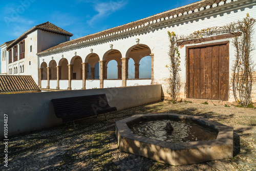 Arch of white building and Fountain in the Generalife palace. Granada. Spain