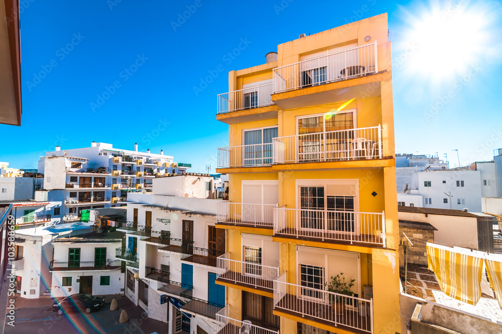 Laundry day.  Ibiza Dazzling sunshine bursting forth in St Antoni de Portmany Balearic Islands, Spain.  Small unit hotels.  Bedding hangs on a clothes line.