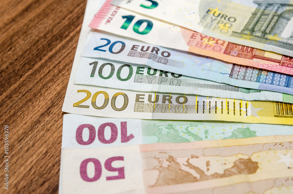 various euro notes on wooden table