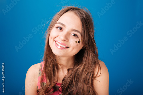 Pretty happy young woman with star shaped decoration on cheek