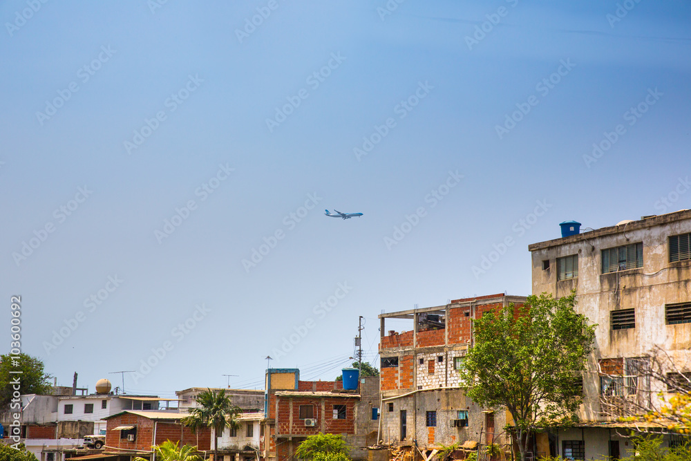 The plane flies over the slums .