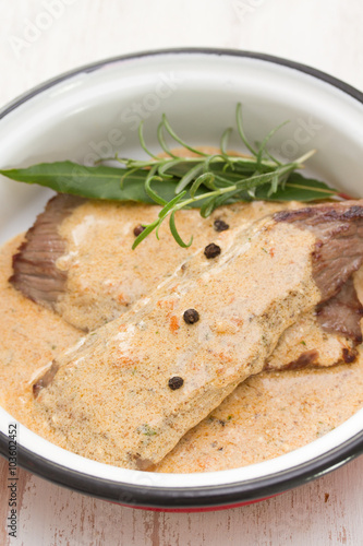 pork with pepper sauce in dish on white wooden background