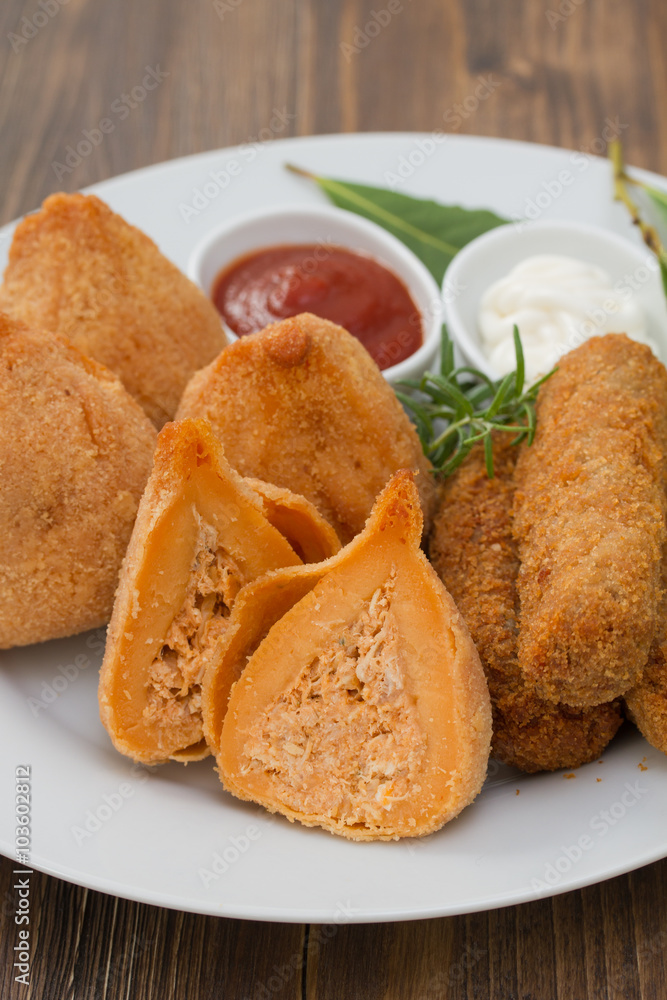 appetizers with sauces on white plate on brown background appetizers with sauces on white plate on brown background