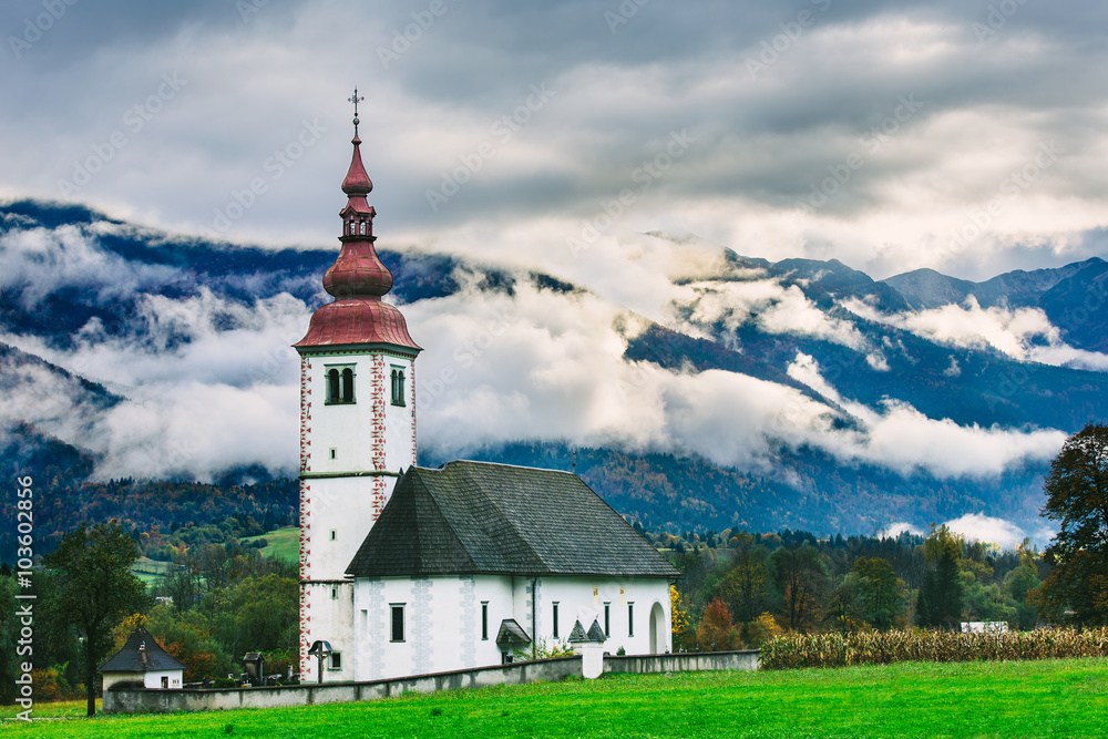 Slovenia landscape near.Bohinj lake. Iconic Slovenian Temple with Beautiful foggy mountains in the background.