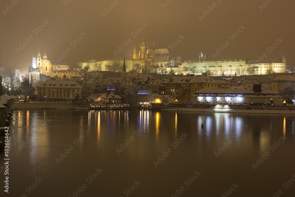 Night romantic snowy Prague gothic Castle with Charles Bridge and St. Nicholas' Cathedral , Czech republic