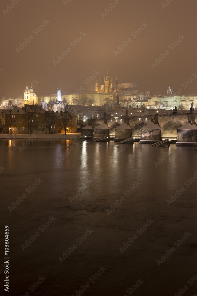 Night romantic snowy Prague gothic Castle with Charles Bridge and St. Nicholas' Cathedral , Czech republic