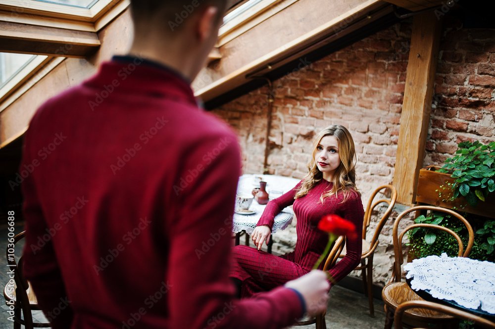 Obraz premium Young beautiful stylish couple in a red dress in love story at t