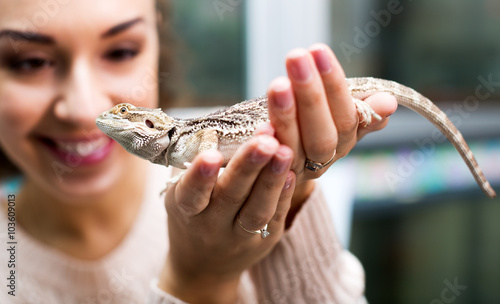 Female customer watching brown gecko photo