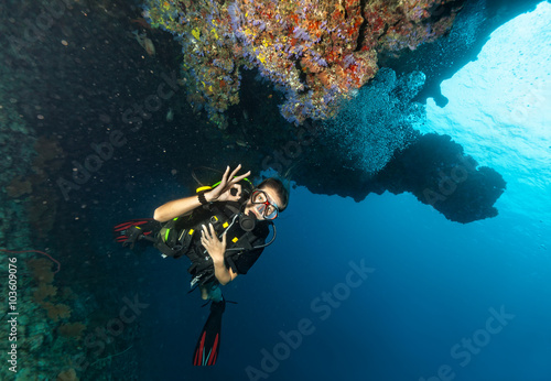 Female scuba diver underwater showing ok signal