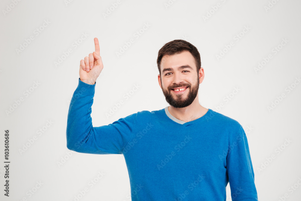 Smiling casual man pointing finger up Smiling casual man pointing finger up