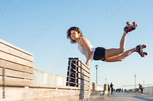 Woman jumping with roller skates photo