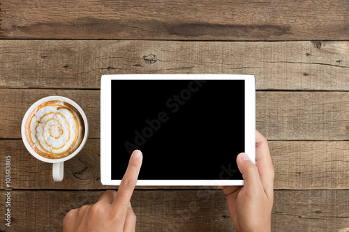 hand using mockup tablet on wood desk with clipping path display easy add element