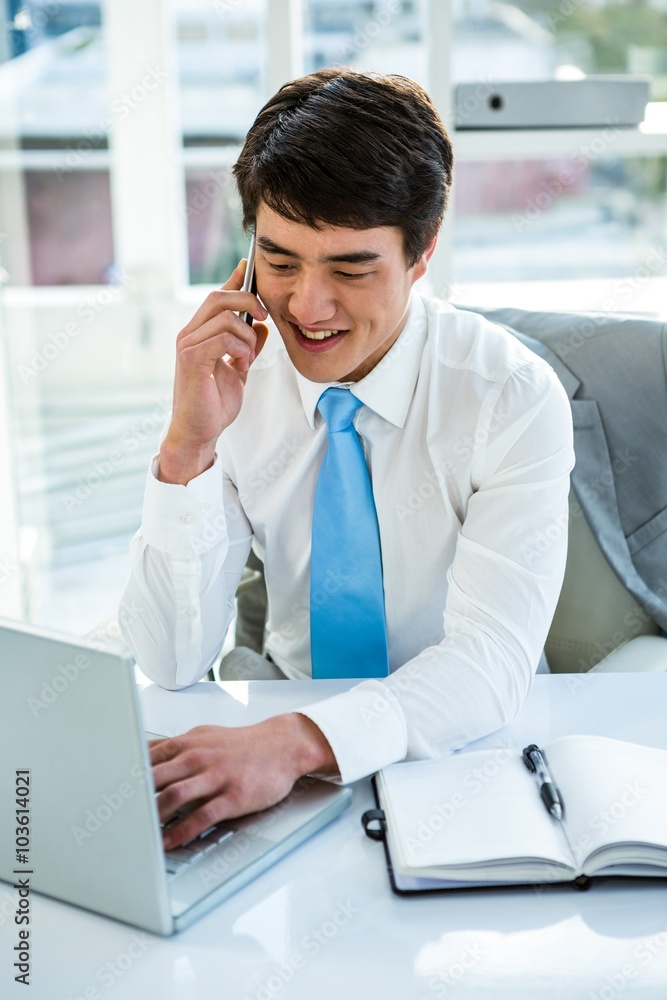 Busy asian businessman working on laptop and calling Busy asian businessman working on laptop and calling