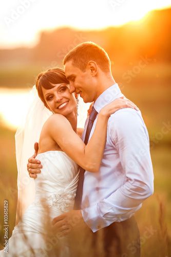 gentle couple is posing on the background beautiful sunset