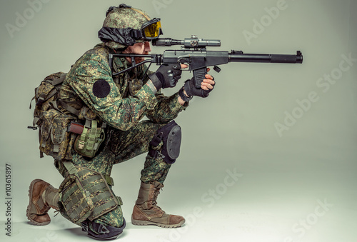 Special forces soldier with rifle on dark background 