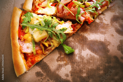 Sliced fresh pizza on cardboard background