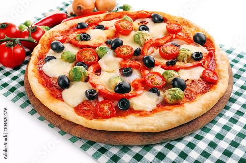 Delicious pizza with cheese and vegetables on green checkered napkin closeup