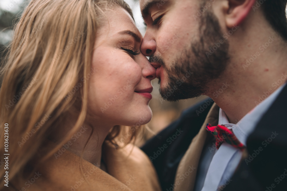 Stylish Loving wedding couple kissing and hugging in a pine forest near retro car Stylish Loving wedding couple kissing and hugging in a pine forest near retro car