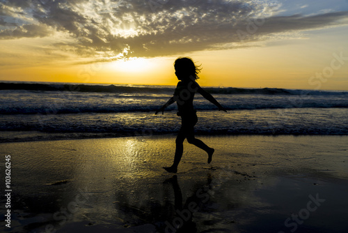 Little girl bathing on the beach at dusk
