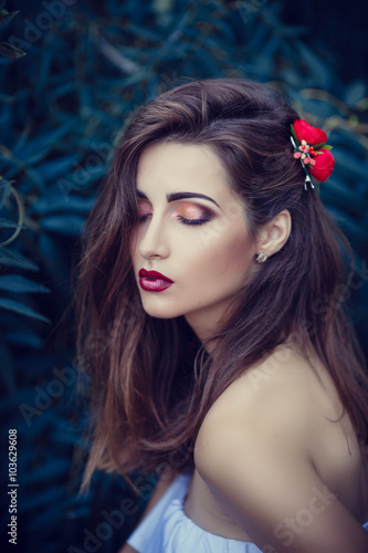 beautiful young brunette woman in a Park at sunset with flower wreath