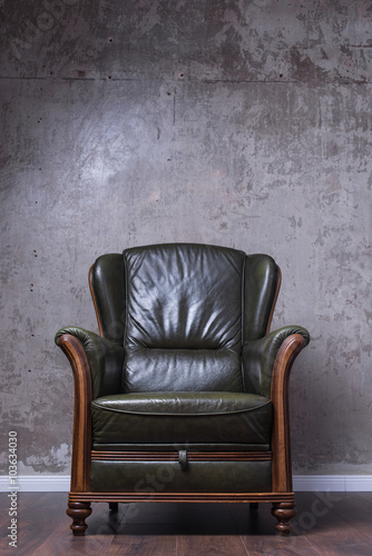 Green leather armchair in front of the wall