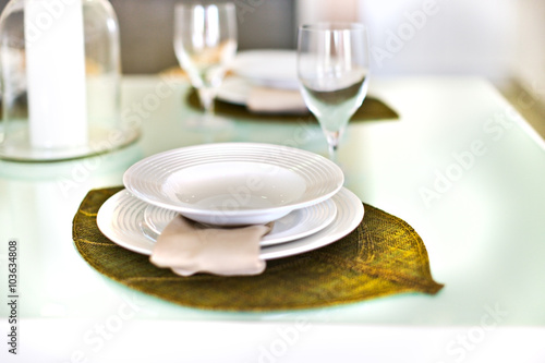 Fototapeta Naklejka Na Ścianę i Meble -  Empty plates on a leaf design and glass with the table set up