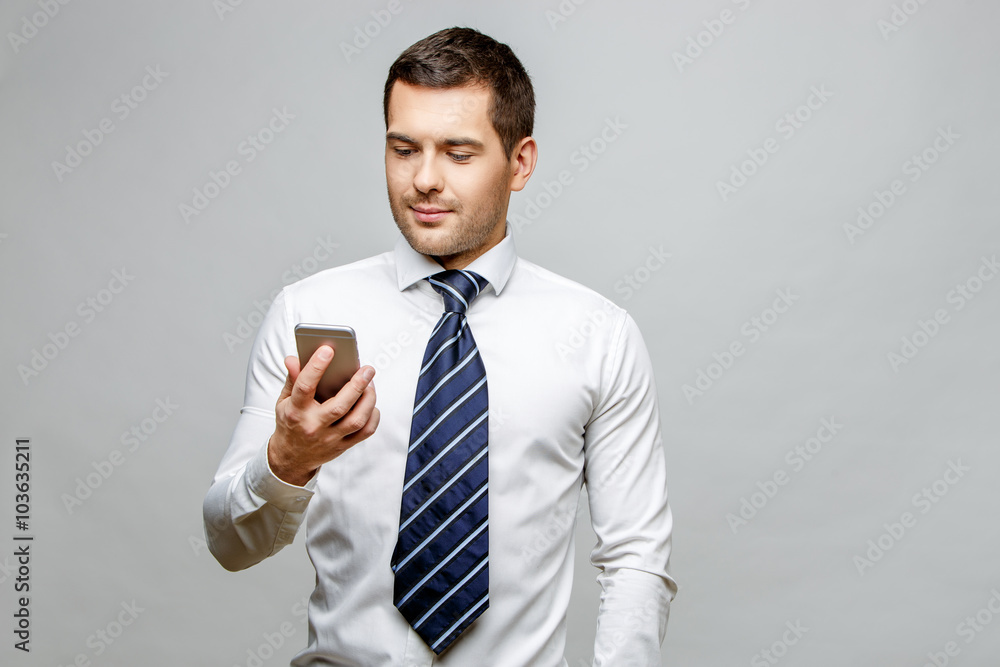 Handsome stylish businessman on grey background Handsome stylish businessman on grey background