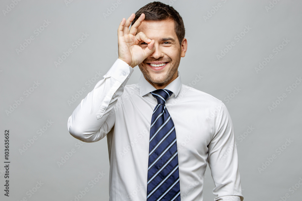 Handsome stylish businessman on grey background Handsome stylish businessman on grey background