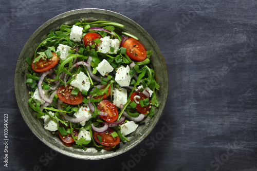 Salad with arugula, tomato, cheese and red onion