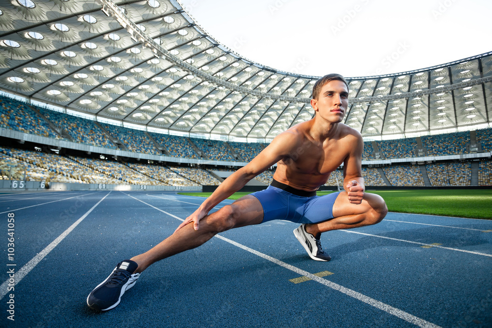 Young sportsman is at large modern stadium Young sportsman is at large modern stadium