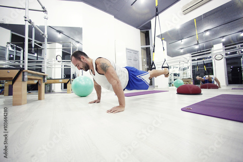 muscular man working in gym with special sport equipment