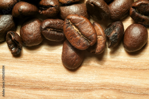Coffee beans on beech tree background close-up
