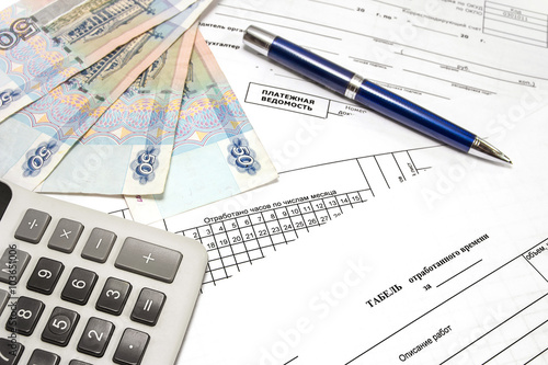Calculator, pen, money and primary documents for payroll