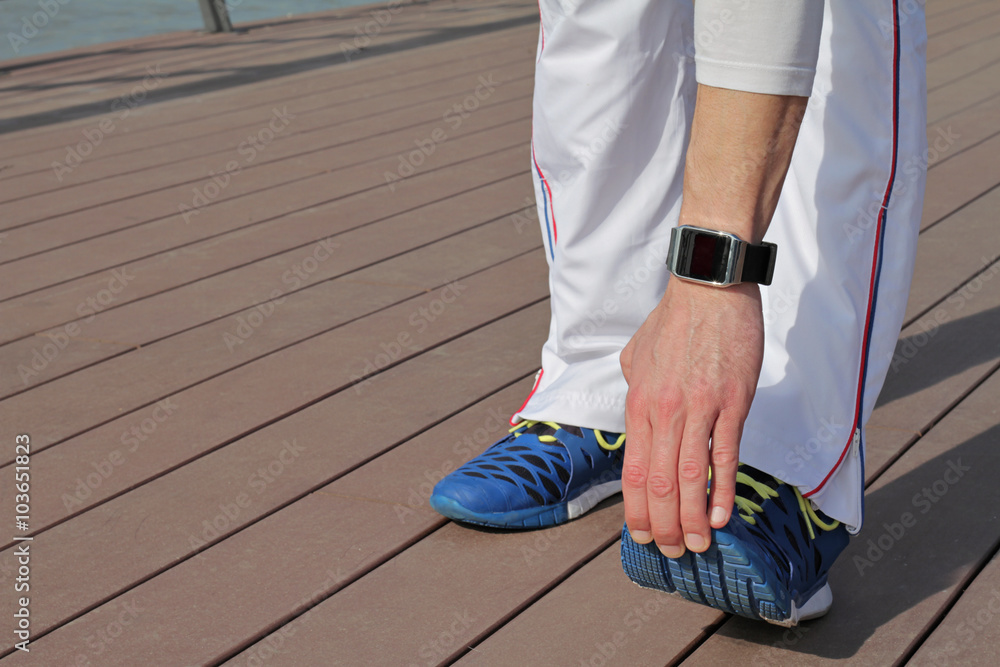 Fototapeta premium Man stretching after workout outdoors close up. Running, sport, healthy active lifestyle concept.