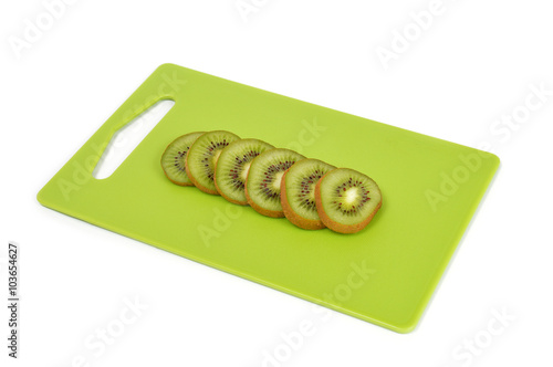 Kiwi on a green cutting board isolated on white
