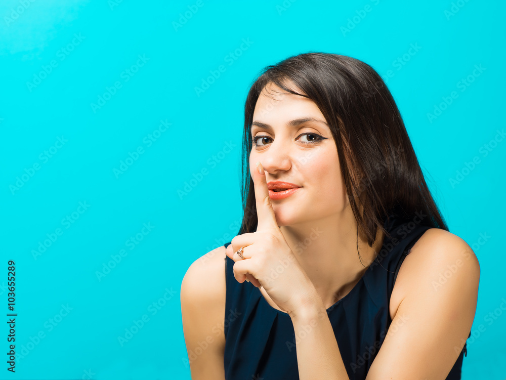 Young woman holding finger on lips Young woman holding finger on lips