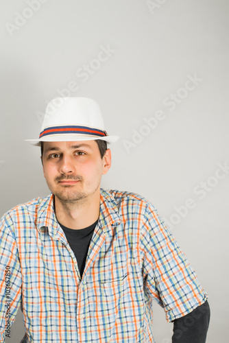 a young man with a hat on a gray background photo