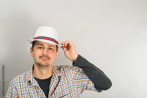 a young man with a hat on a gray background photo