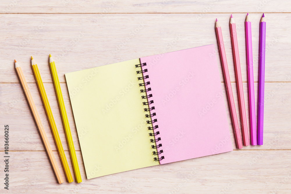 Obraz premium Open notebook with pink and yellow pencils
