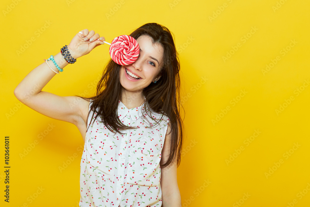 teenage woman smiling and holding a lollipop teenage woman smiling and holding a lollipop