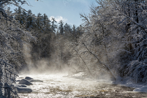 Photography Fog rises into sunny sub-zero skies over the West fork of the Chippewa River in northern Wisconsin