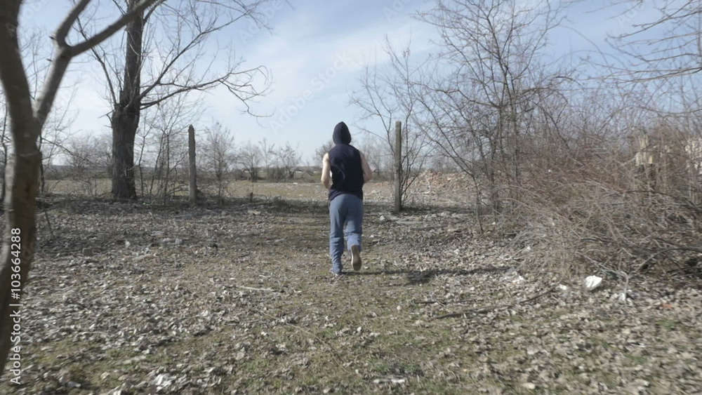 Young hooded man jogging in an abandoned place Young hooded man jogging in an abandoned place