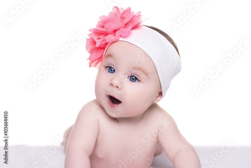 portrait of cute little baby girl with pink bow flower on her he