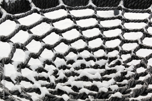 Snowy circular net of a rope swing